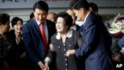 Lee Hee-ho, the widow of former South Korean President and Nobel Peace Prize laureate Kim Dae-jung, is escorted after speaking to the media at Gimpo International Airport in Seoul, South Korea, after returning from North Korea, Aug. 8, 2015. 