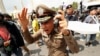 A police officer reacts during clashes between pro-democracy demonstrators and royalists during a anti-government protest on the 47th anniversary of the 1973 student uprising, in Bangkok, Thailand.