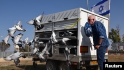 FILE - A member of the Racing Pigeon Club of Israel releases homing pigeons in a ceremony to request the return of hostages from Gaza, at the entrance to Kibbutz Beeri following the deadly October 7 attack in southern Israel, December 4, 2023.