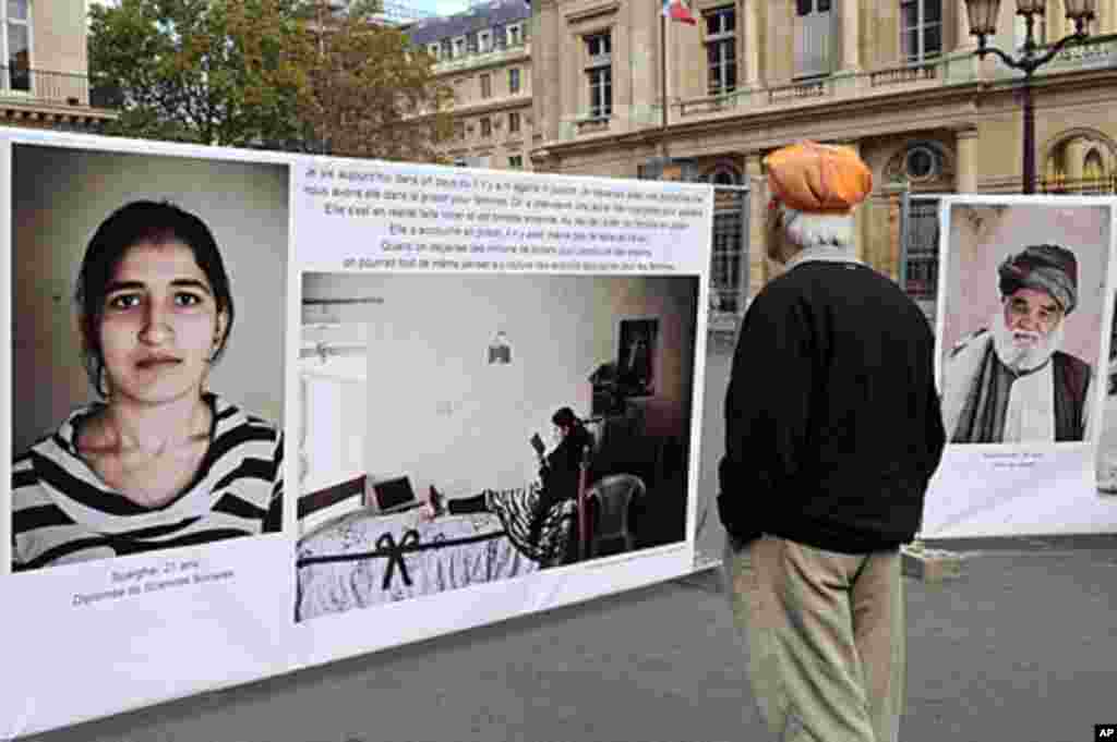 2011年10月7日，军事干预阿富汗10周年之际，一名男子在巴黎的游行中观看阿富汗照片。