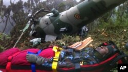 In this photo provided by the Kenyan military, Chris Kasiji, a senior Ugandan air force pilot, is rescued from the wreckage of a helicopter on Mount Kenya, August 13, 2012.