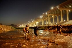 Migrantes cruzan el río Bravo para entregarse a los agentes de la Patrulla Fronteriza de EE. UU. para solicitar asilo en El Paso, Texas, EE. UU., (Visto desde Ciudad Juárez).