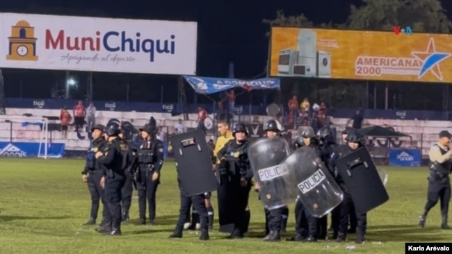 ARCHIVO - Un grupo antimotines custodia al equipo de árbitros que intenta salir del estadio Las Victorias, en Chiquimula, Guatemala, mientras asistentes al partido entre el Sacachispas y el Suchitepéquez los espera para abuchearlos, el 16 de noviembre de 2024.