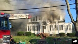 Petugas pemadam kebakaran berupaya memadamkan api di sebuah rumah, di Herrick Road, North Andover, Massachussets, Kamis, 13 September 2018.