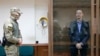 FILE -Ivan Safronov, an adviser to the director of Russia's state space corporation, stands in a cage in a courtroom in Moscow, July 16, 2020. Safronov, who rose to prominence as a journalist, was arrested this month on treason charges.