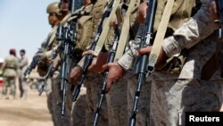 FILE - Saudi soldiers stand in line at an airfield where Saudi military cargo planes land to deliver aid in Marib, Yemen, Jan. 26, 2018. 