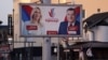 Warga berjalan melintasi papan iklan yang berisi gambar tokoh politisi Milorad Dodik dan Zeljka Cvijanovic dari Aliansi Independen Sosial Demokrat di Gradiska, Bosnia dan Herzegovina, pada 28 September 2022. (Foto: Reuters/Dado Ruvic)