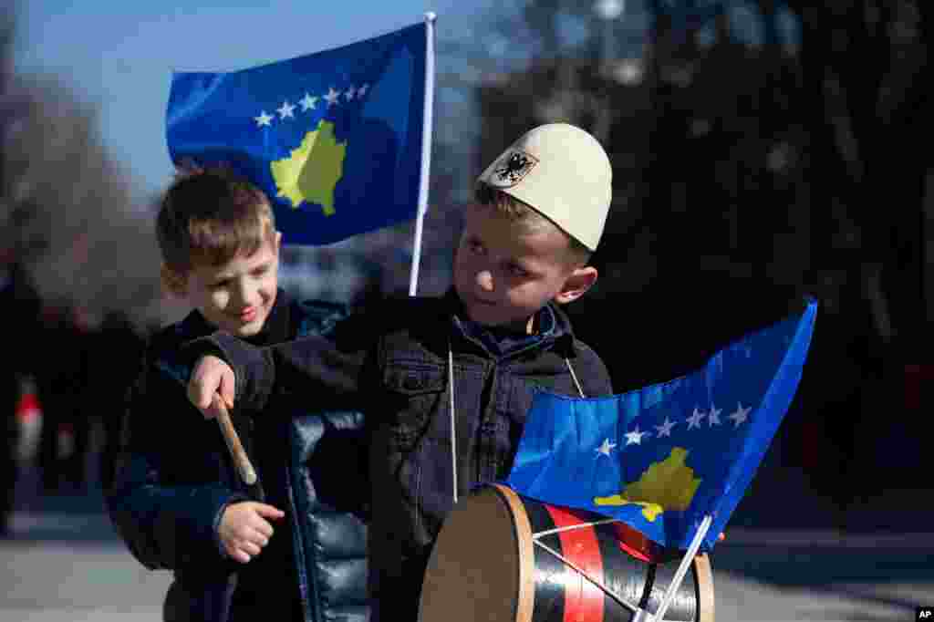 A boy plays on a drum decorated with Kosovo&#39;s flag to celebrate the 12th anniversary of the country&#39;s independence, in the capital Pristina.