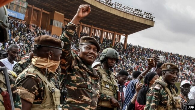 FILE - General Abdourahamane Tiani (2nd L), the head of the military regime in Niger, greets the thousands of people who gathered in Niamey for the launch of festivities marking the first anniversary of his coming to power after a July 26, 2023 coup.