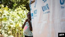 FILE - A young girl stands by her shelter at a camp for internally displaced people (IDPs) in Kaya, Burkina Faso, Oct. 14, 2020.