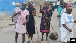 FILE - A group of women sweep a main street in the fishing village of Cotes-de-Fer, Haiti, Oct. 25, 2014.