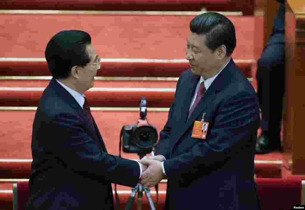 China&#39;s newly-elected President Xi Jinping shakes hands with former President Hu Jintao during the fourth plenary meeting of the National People&#39;s Congress (NPC) at the Great Hall of the People in Beijing.