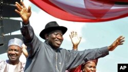 Shugaban kasar Najeriya Goodluck Jonathan (C),tare da matarshi Patience (R), Mataimakin shugaban kasa Namadi Sambo, yana dagawa jama'a hannu kafin kaddamar da kamfen dinsa a Abuja.