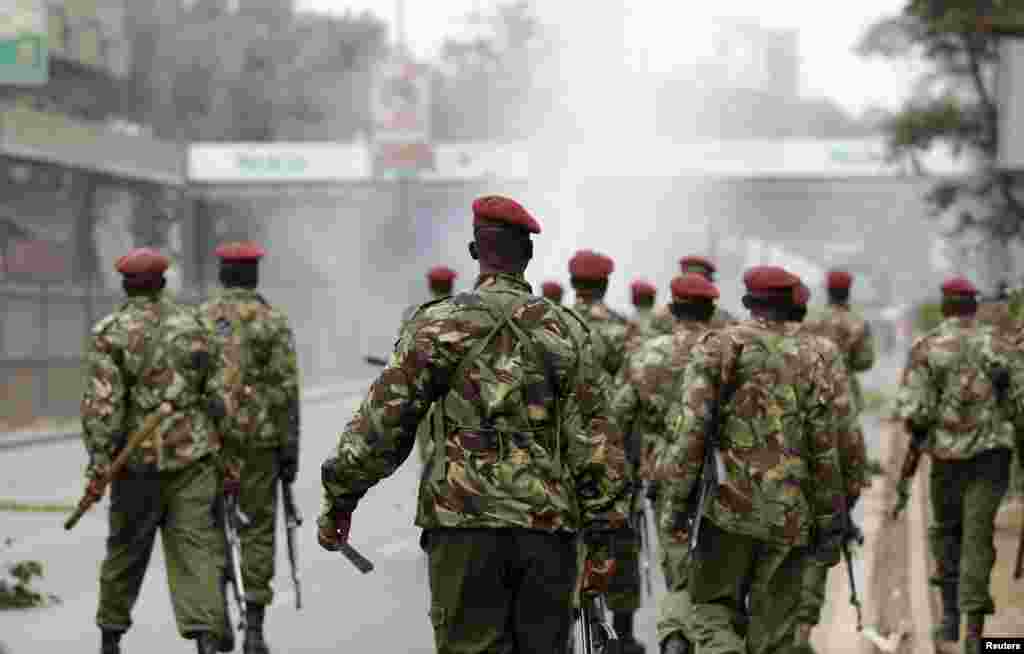 Riot police walk down the street after firing tear gas to disperse supporters of Kenya's opposition Coalition for Reforms and Democracy before their "Saba Saba Day" rally at the Uhuru park grounds in Nairobi, July 7, 2014.