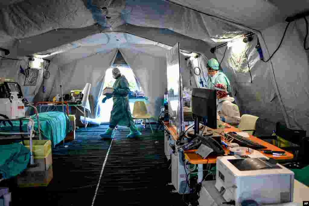 Medical personnel work inside one of the emergency structures that were set up to ease procedures outside the hospital of Brescia, Italy.