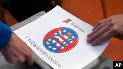 Kotak suara bertuliskan 'Pemilihan ke Parlemen Thuringian' di salah satu TPS di Erfurt, Jerman, Minggu, 27 Oktober 2019. (Foto AP / Jens Meyer)
