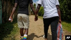 FILE - Gay Ugandan refugees who fled from their country to neighboring Kenya, return after shopping for food in Nairobi, Kenya on June 11, 2020. 