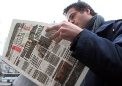 A man reads the Polish newspaper Gazeta Wyborcza in Warsaw Nov. 23, 2005. Two leading Polish daily newspapers blacked out most of their front pages to protest violations of press freedoms in Belarus.