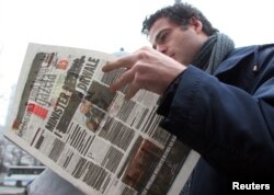 A man reads the Polish newspaper Gazeta Wyborcza in Warsaw Nov. 23, 2005. Two leading Polish daily newspapers blacked out most of their front pages to protest violations of press freedoms in Belarus.