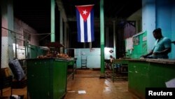 FILE - A Cuban flag decorates a subsidized state store, or "bodega," where Cubans can buy basic products with a ration book they receive annually from the government, in downtown Havana, Cuba, Nov. 22, 2017. 