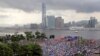 Manifestantes pro China sostienen banderas chinas y carteles que leen "Apoyamos a la policía" durante una manifestación afuera de la legislatura en Hong Kong, el domingo 30 de junio del 2019. (AP Foto/Kin Cheung)