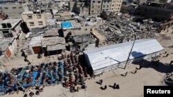 Warga Palestina melaksanakan salat Jumat pertama selama Ramadan di dekat reruntuhan masjid yang hancur, di Rafah, di selatan Jalur Gaza, 15 Maret 2024. (Foto: REUTERS/Mohammed Salem)