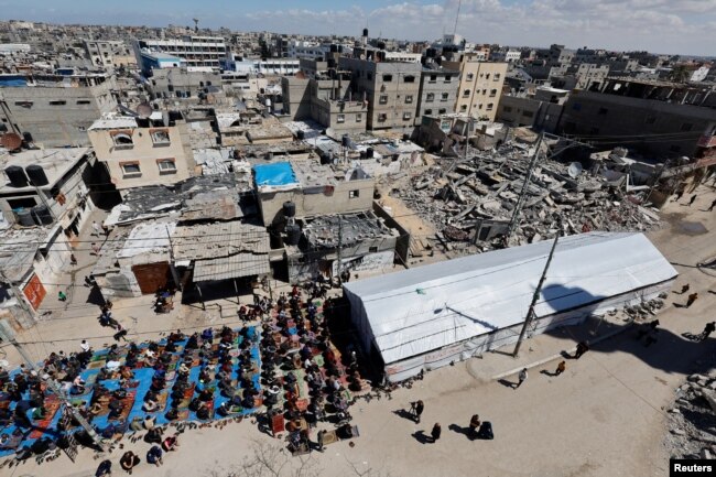 Warga Palestina melaksanakan salat Jumat pertama selama Ramadan di dekat reruntuhan masjid yang hancur, di Rafah, selatan Jalur Gaza, 15 Maret 2024. (Foto: REUTERS/Mohammed Salem)