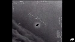 The image from video provided by the Department of Defense labelled Gimbal, from 2015, an unexplained object is seen at center as it is tracked as it soars high along the clouds, traveling against the wind.