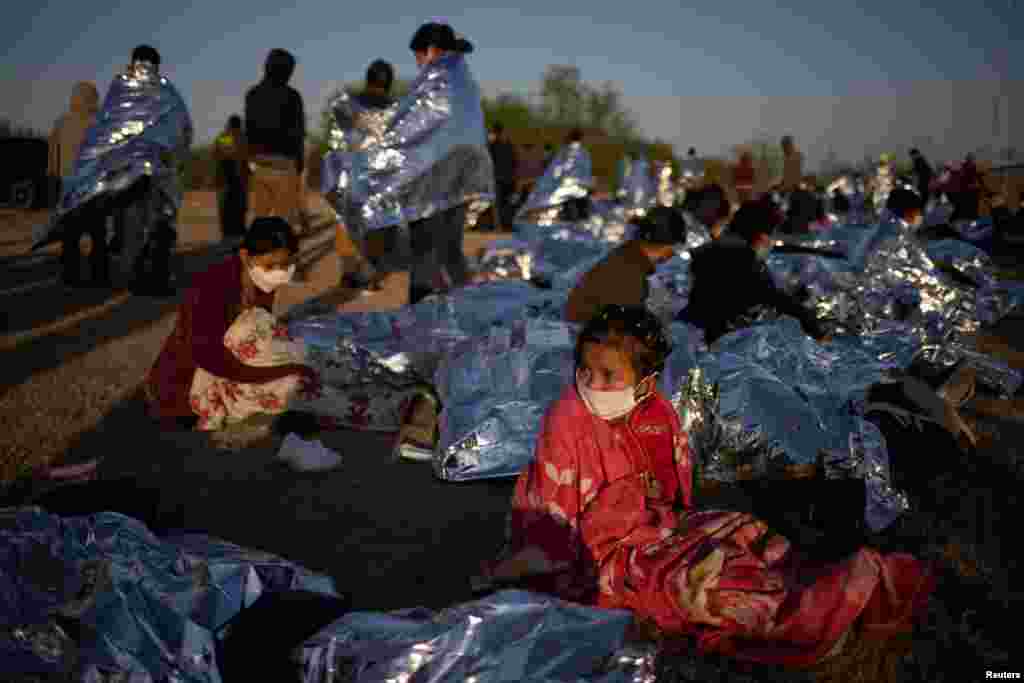 A four year old asylum-seeking migrant girl from Honduras awakes next to others who crossed the Rio Grande river into the U.S from Mexico on rafts, in La Joya, Texas.