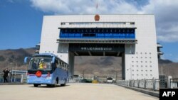 Sebuah bus wisata melaju melewati perbatasan China dan Korea Utara, di Ji'an di provinsi Jilin timur laut China, menuju Korea Utara, 8 April 2019. (AFP). 