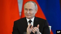 Presiden Rusia Vladimir Putin bertepuk tangan saat menghadiri upacara penandatanganan setelah pembicaraannya dengan Putra Mahkota Bahrain dan Perdana Menteri Salman bin Hamad bin Isa Al Khalifa di Kremlin di Moskow, Rusia, Kamis 23 Mei 2024. (Foto: via AP)