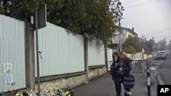 Women pay respects outside the Ozar Hatorah Jewish school, in Toulouse, France, March 23, 2012 where three children and a rabbi were gunned down.