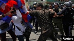Protesters clash with police as they attempt to move toward the Phnom Penh Municipal Court, in central Phnom Penh, Cambodia, April 25, 2014.