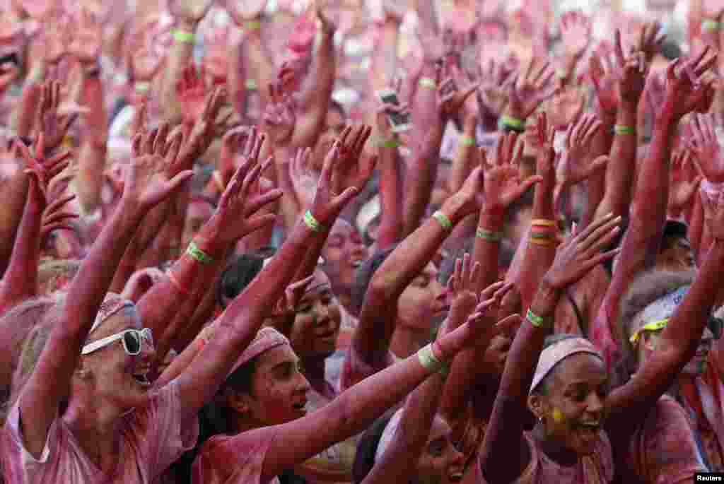 Para peserta bersorak di daerah garis finish lomba lari The Color Run di Pulau Sentosa, Singapura. The Color Run adalah lomba lari 5 kilometer tanpa diukur waktunya yang diselenggarakan di seluruh dunia untuk mendorong gaya hidup sehat dan kegiatan amal di masing-masing tempat.&nbsp;