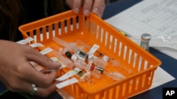 FILE - Vaccines are prepared for students during a pop-up immunization clinic at the Newcomer Academy in Louisville, Ky., on Aug. 8, 2024.