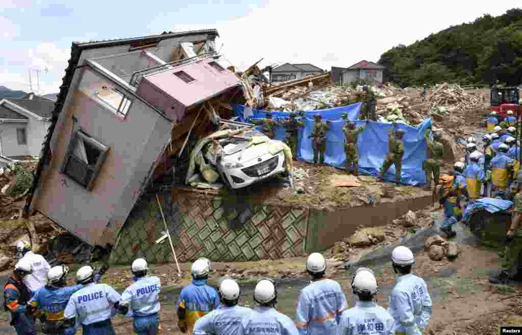 共同社拍摄的照片显示，日本救援人员在广岛搜寻豪雨后的失踪者和遇难者（2018年7月9日）。