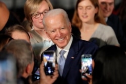 Democratic presidential candidate former Vice President Joe Biden poses for photos at a primary night election rally in Columbia, S.C., Feb. 29, 2020.
