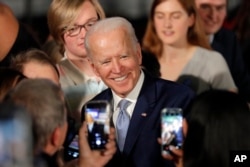 Democratic presidential candidate former Vice President Joe Biden poses for photos at a primary night election rally in Columbia, S.C., Saturday, Feb. 29, 2020.