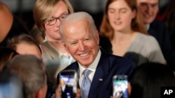 Democratic presidential candidate former Vice President Joe Biden poses for photos at a primary night election rally in Columbia, S.C., Feb. 29, 2020.