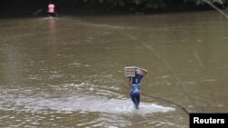 A man carries a carton of eggs across a river in the border town of Boca del Grita in the state of Tachira, Venezuela, Sept. 8, 2015.