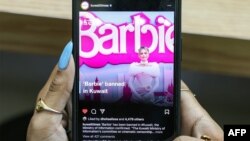 FILE - A woman views a post published by the Kuwait Times on their official Instagram account reporting on the ban of the 2023 film "Barbie" in Kuwait, in Kuwait City on August 10, 2023.