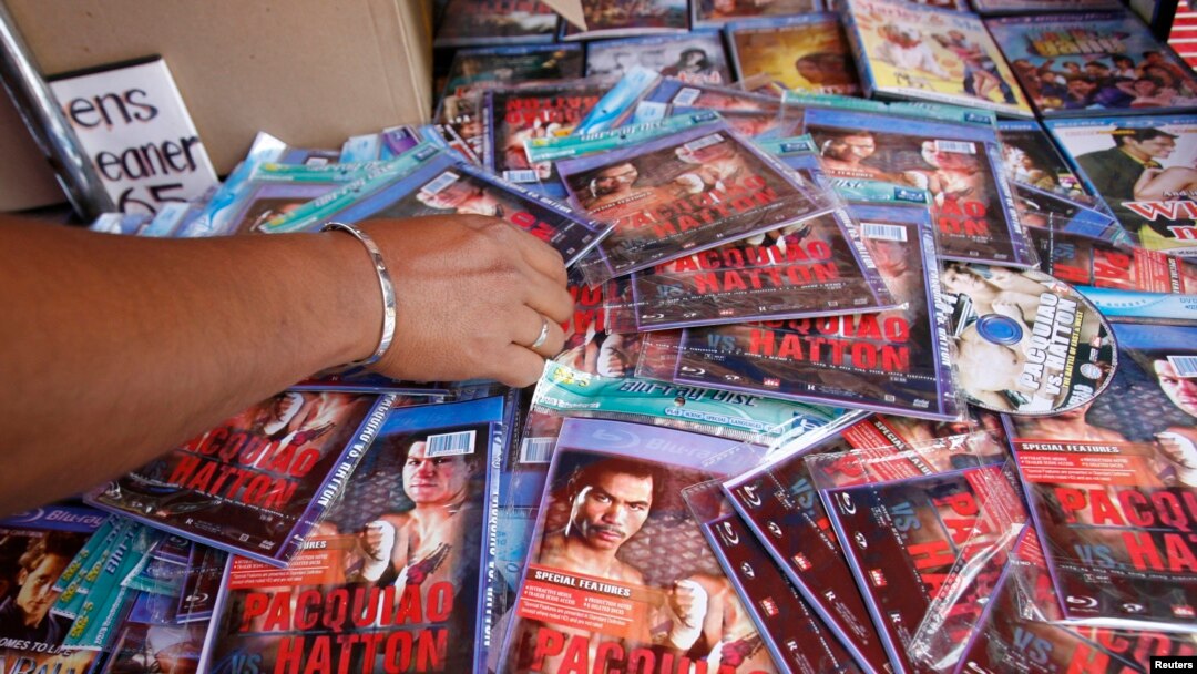 FILE - A policeman looks at pirated Digital Video Disks (DVD) of a fight between Manny 'Pacman' Pacquiao of Philippines and Ricky Hatton of Britain during a raid in Manila.