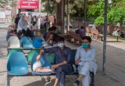 People sit in waiting area of the Benazir Hospital ignore social distancing, during a lockdown to contain the spread of coronavirus, in Rawalpindi, Pakistan, April 22, 2020.