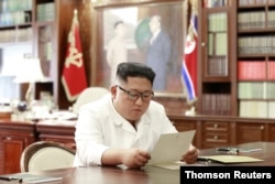 FILE - North Korean leader Kim Jong Un reads a letter from U.S. President Donald Trump, in Pyongyang, North Korea, in this picture released by North Korea's Korean Central News Agency, June 22, 2019.