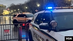 Law enforcement officers in their cruisers patrol a section of Pennsylvania Avenue, off limits to pedestrians, near the White House, in Washington, Jan. 19, 2025. (Carolyn Pressutti/VOA)