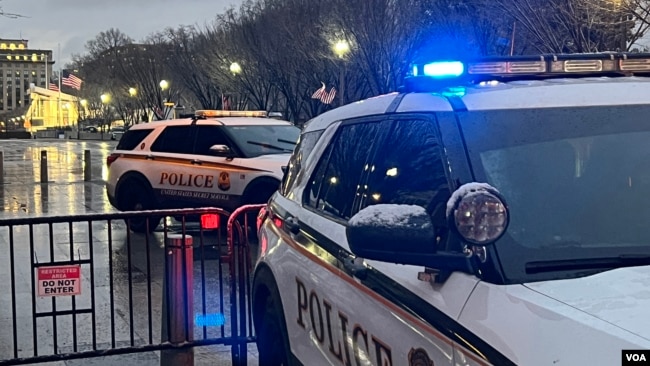 Law enforcement officers in their cruisers patrol a section of Pennsylvania Avenue, off limits to pedestrians, near the White House, in Washington, Jan. 19, 2025. (Carolyn Pressutti/VOA)