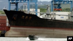 Seorang polisi berpatroli menggunakan perahu di dekat kapal Korea Utara "Chong Chon Gang" di terminal peti kemas internasional Manzanillo di Colon City, Panama (Foto: dok). Panama telah membebaskan nahkoda dan awak kapal ini, Jumat (28/6).