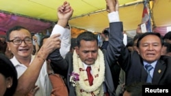 Meach Sovannara (C), a member of the Cambodia National Rescue Party cries next to CNRP President Sam Rainsy (L) and Deputy President Kem Sokha before a Buddhist ceremony at the CNRP office in Phnom Penh, Cambodia, April 13, 2015.