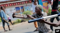 Un manifestant utilise un lance-pierre au cours des affrontements avec les forces de sécurité dans le quartier de Cibitoke de la capitale Bujumbura, Burundi vendredi 29 mai 2015.