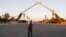FILE - An Iraqi security officer walks near the "Arch of Victory" memorial in the Green Zone of Baghdad, Iraq July 15, 2019.